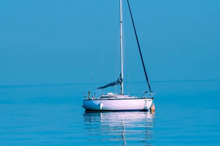 A yacht at anchor on flat water