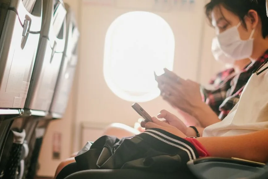 A passenger using a phone on board a flight