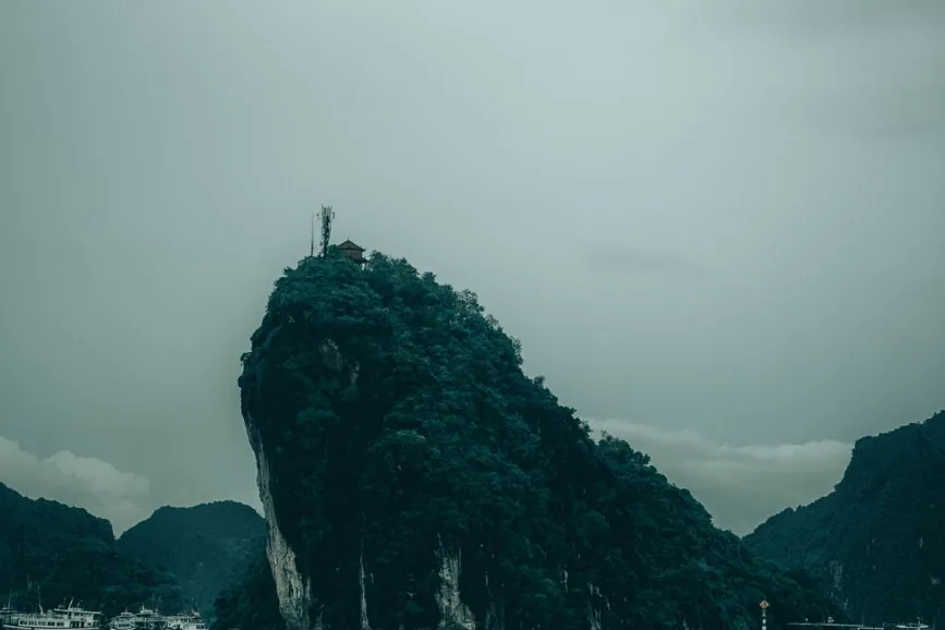 A limestone karst rising from Halong Bay under grey cloud